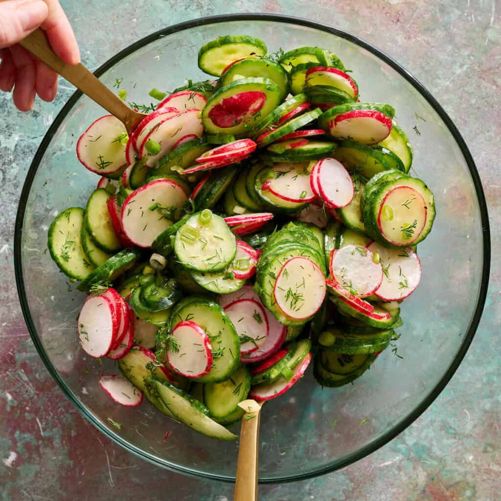 tossing salad in a bowl