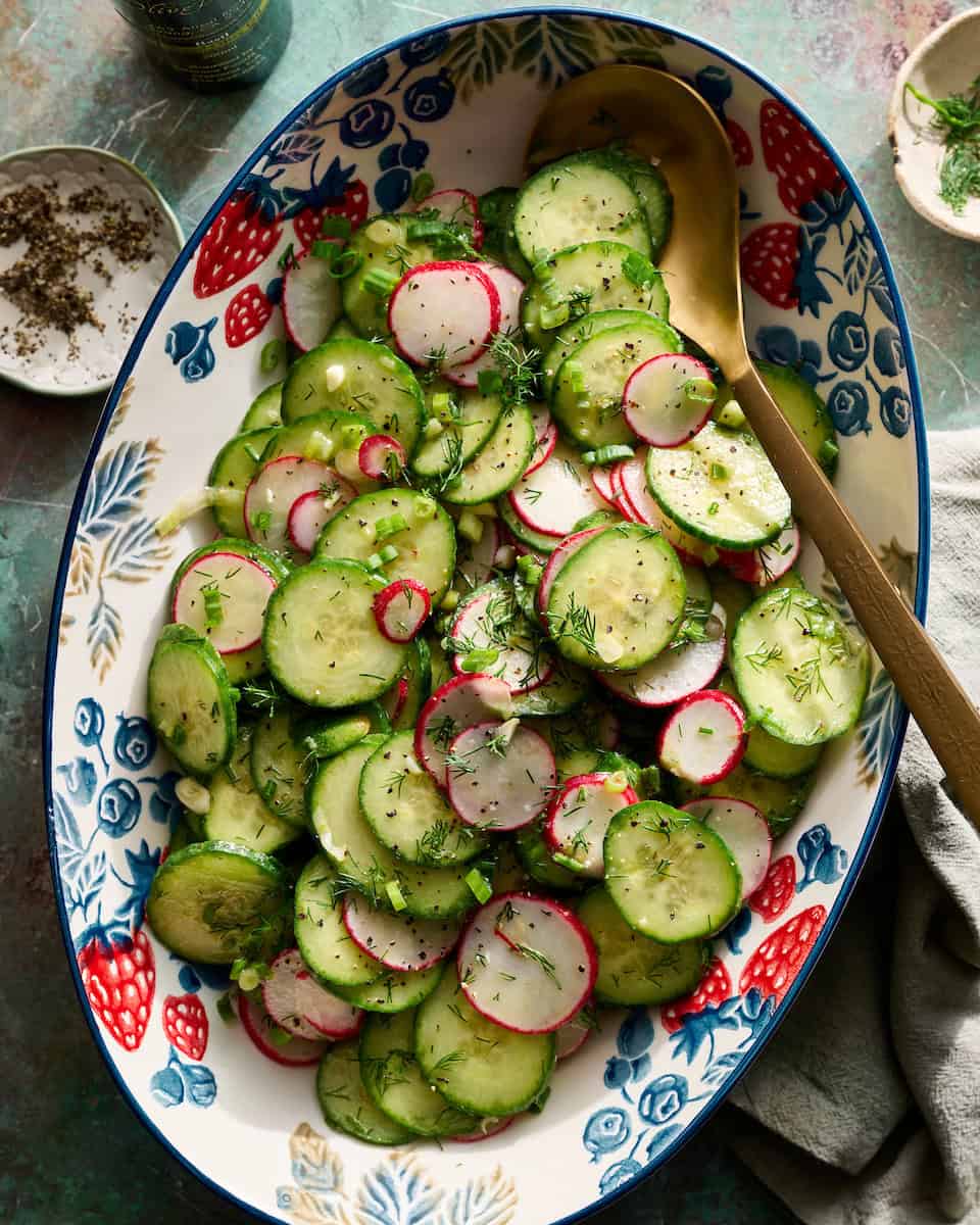 radish and cucumber salad tossed in a bowl