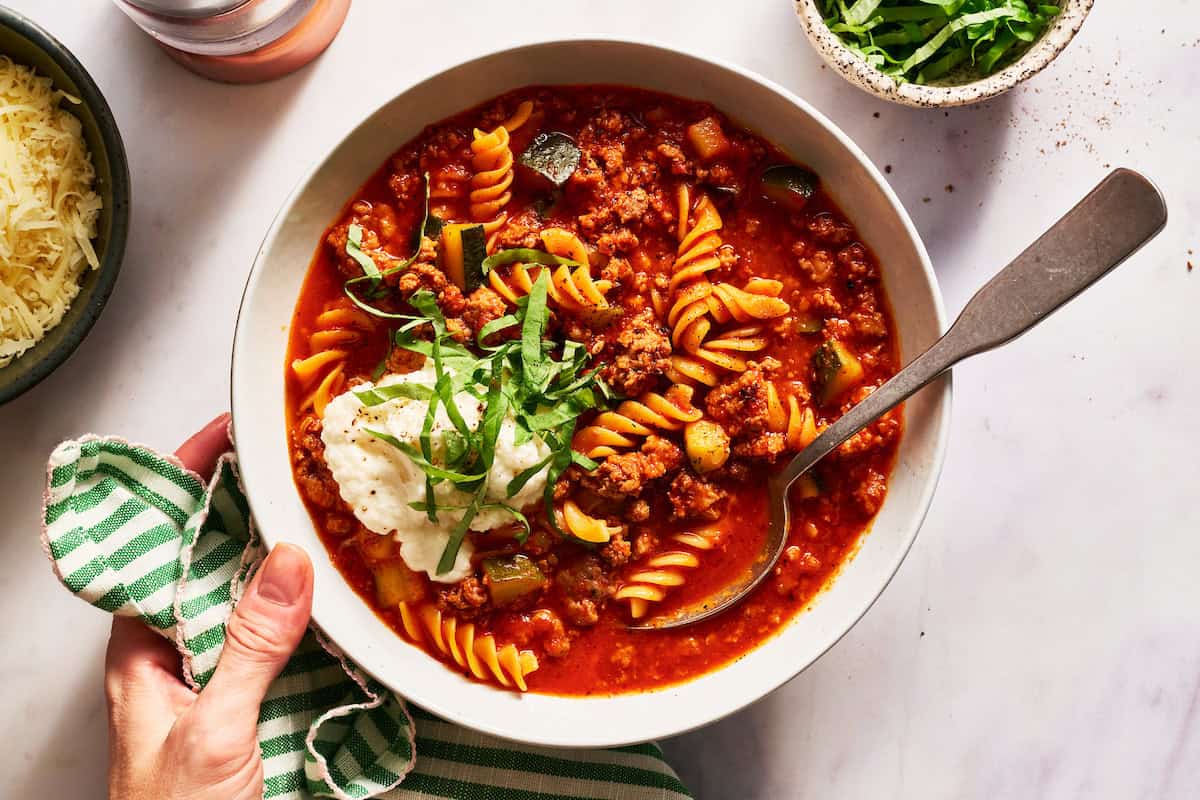 bowl of lasagna soup served with ricotta and basil