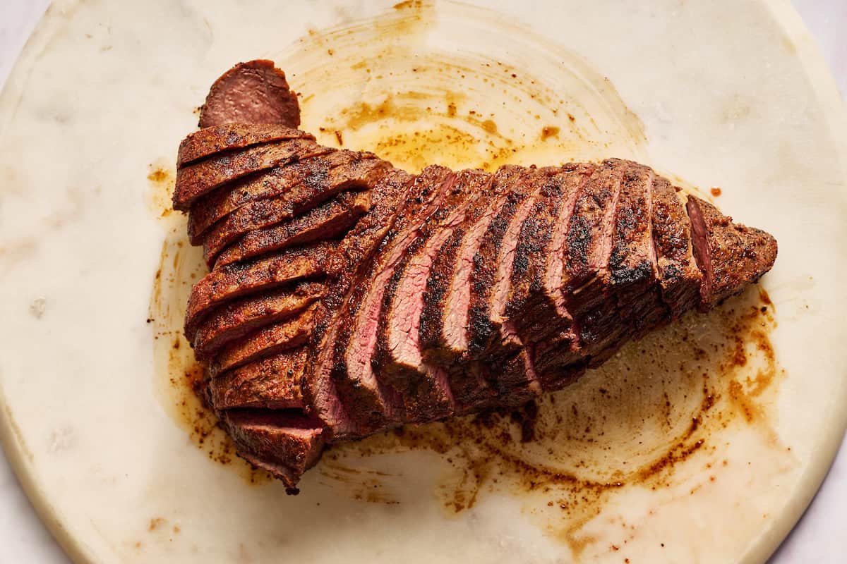 showing how to slice a tri tip roast properly against the grain in two sections