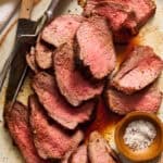 tri tip roast on a serving platter sprinkled with salt and pepper