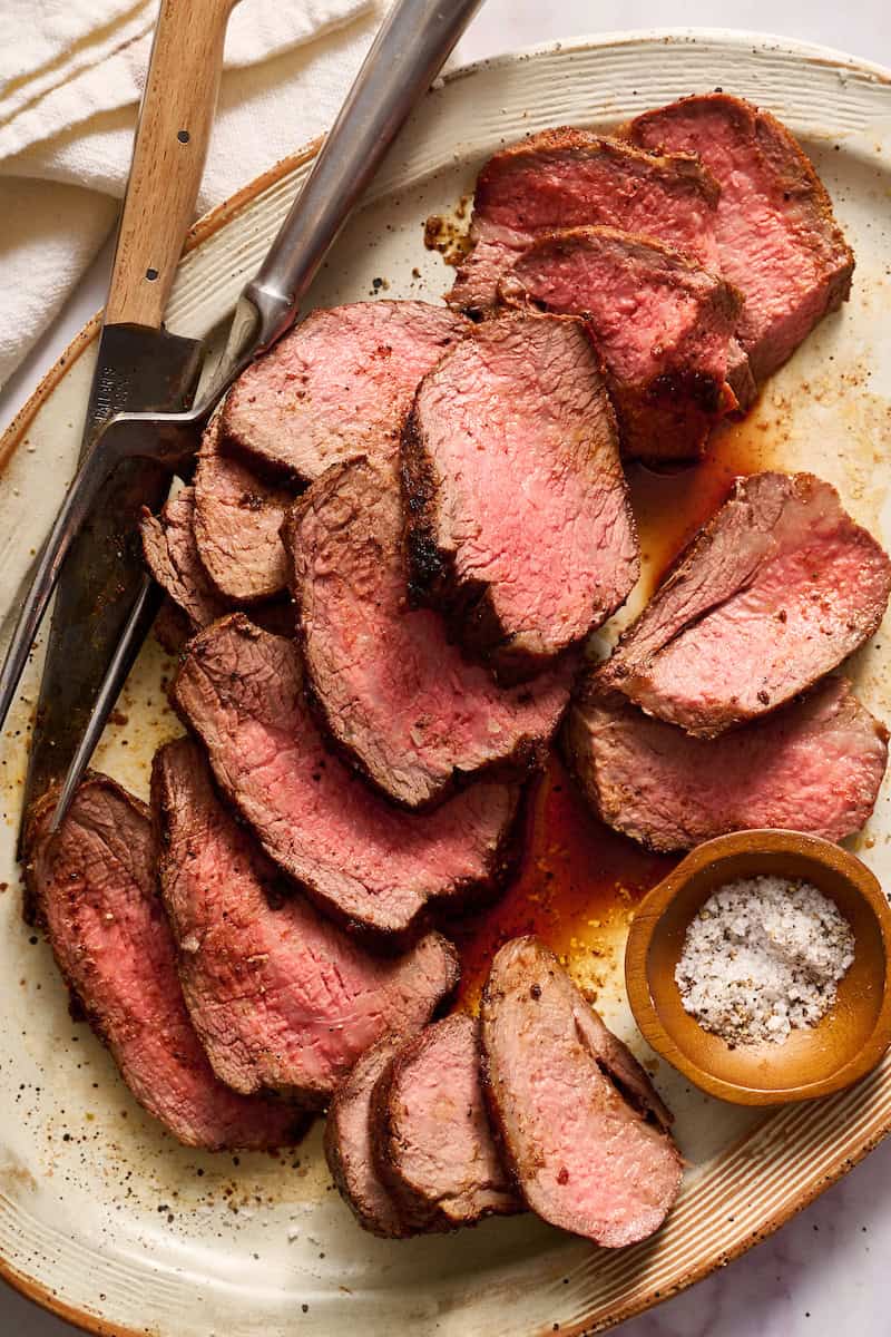 tri tip roast on a serving platter sprinkled with salt and pepper