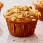 Sourdough discard banana nut muffins with golden domed tops topped with walnuts