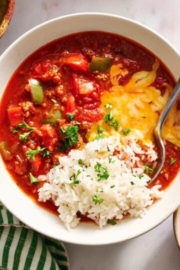 bowl of stuffed pepper soup served with rice, parsley and cheese