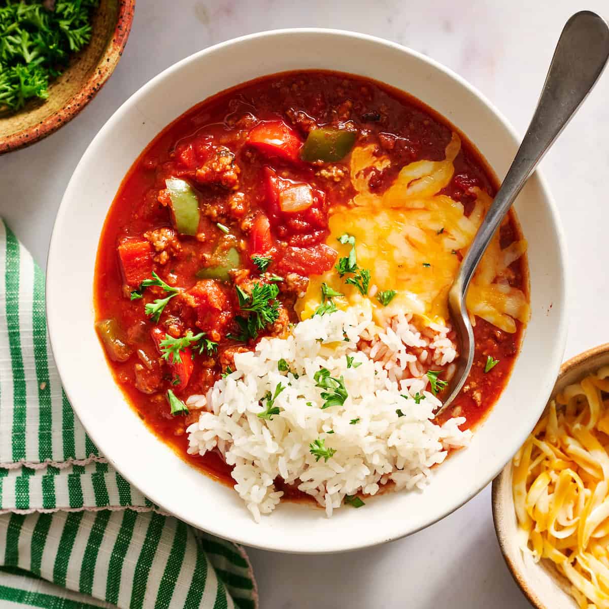 bowl of stuffed pepper soup served with rice, parsley and cheese