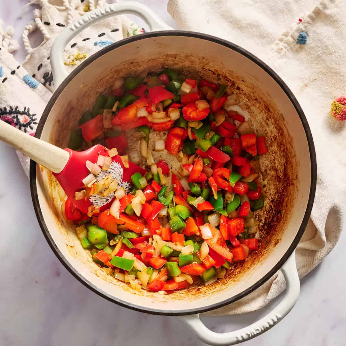 cooking peppers and onions in a large pot with beef drippings