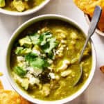 Bowl of chicken chili verde topped with cilantro served with chips