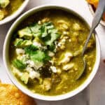 Bowl of chicken chili verde topped with cilantro served with chips