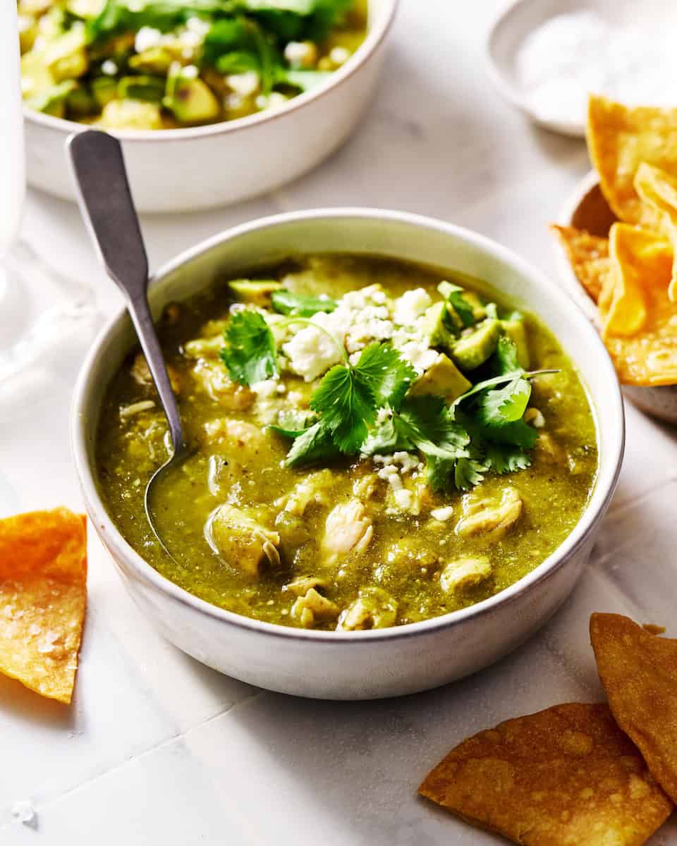 Bowl of chicken chili verde topped with cilantro served with chips