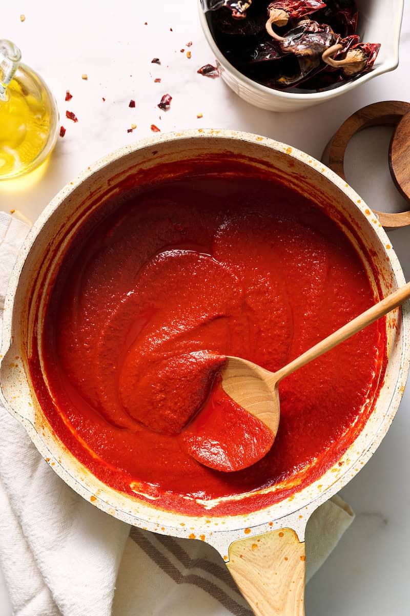 Finished sauce in a saute pan with dried chilies on the side