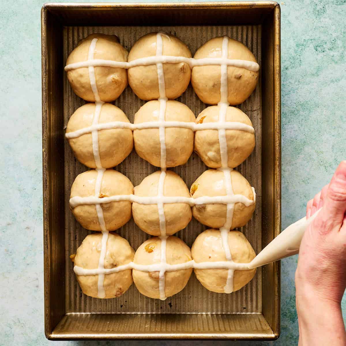 piping discard onto the tops of the rolls to create crosses