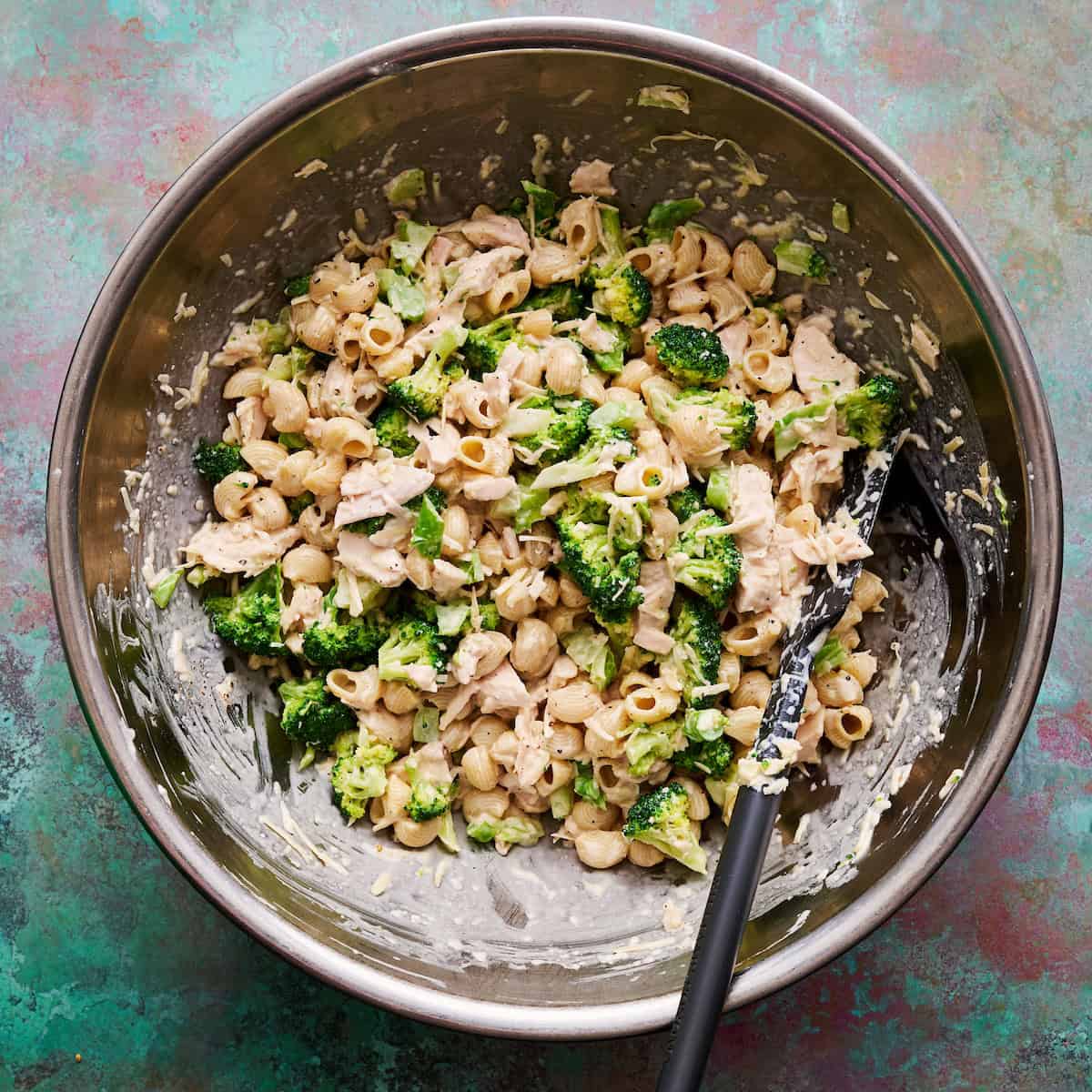 pasta salad all mixed up in a mixing bowl