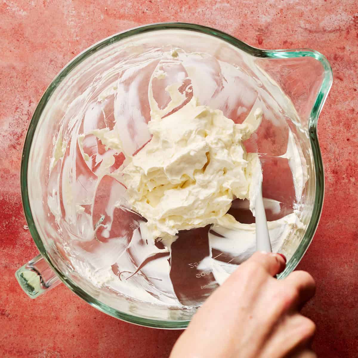 beating the cream cheese until smooth in a mixing bowl