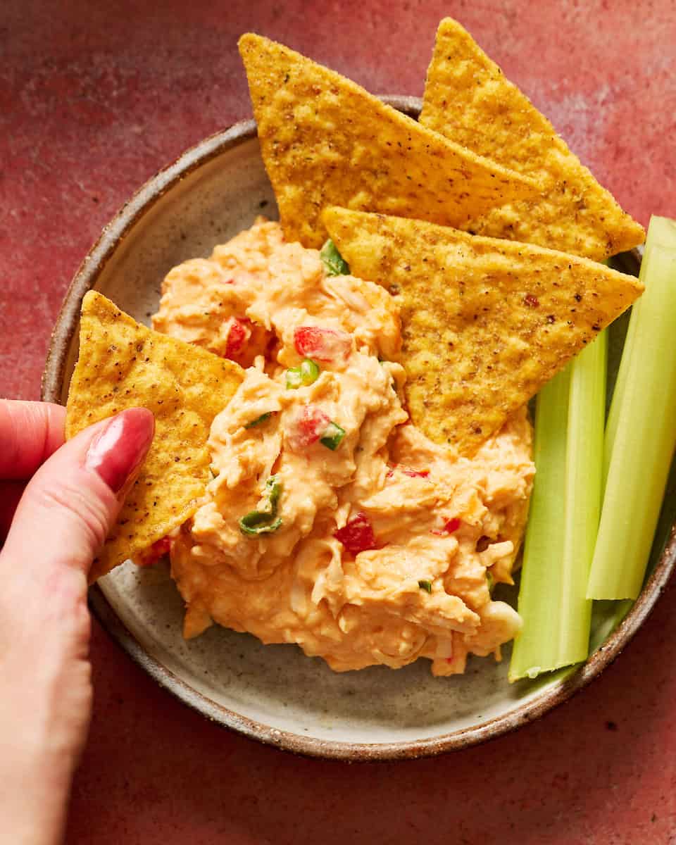 Delicious low-carb chicken dip with tortilla chips and celery sticks.