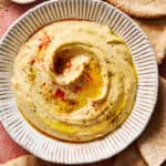 homemade hummus topped with paprika and olive oil served with pita