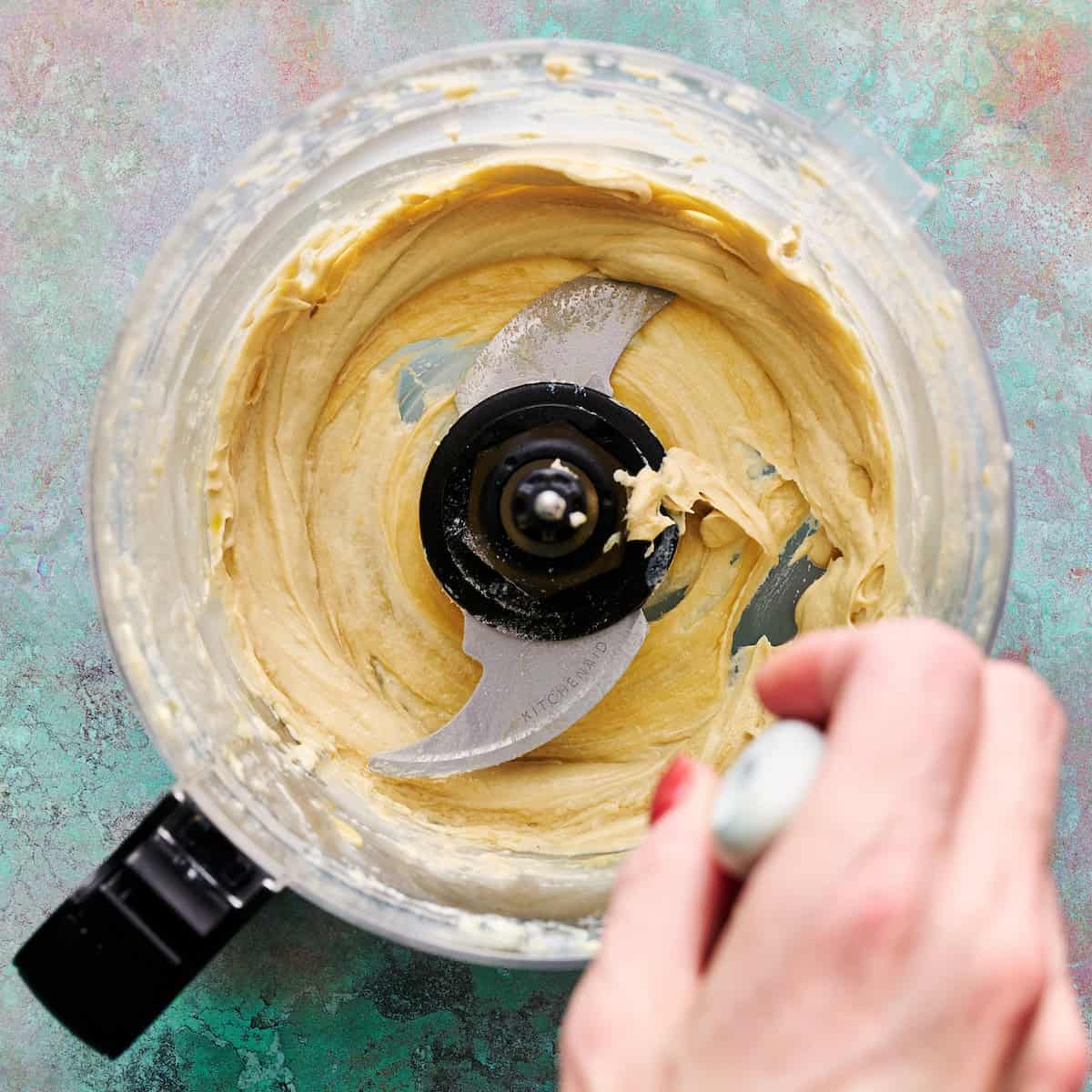 scraping down the sides of the bowl after whipping the olive oil, lemon and tahini