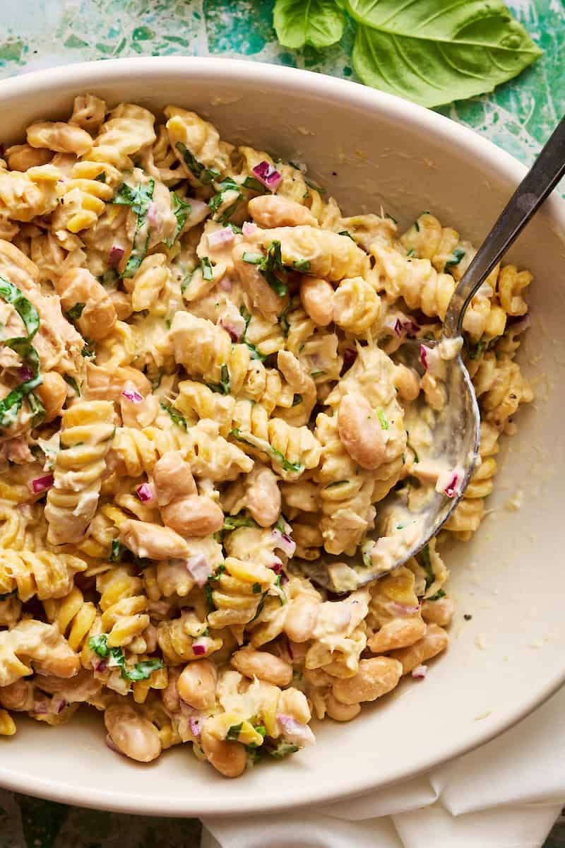 pasta salad in a serving bowl with some scooped out and served