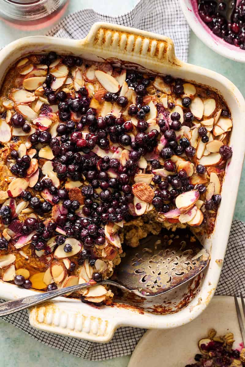 closeup of a pan of baked oats topped with blueberries and toasted almonds