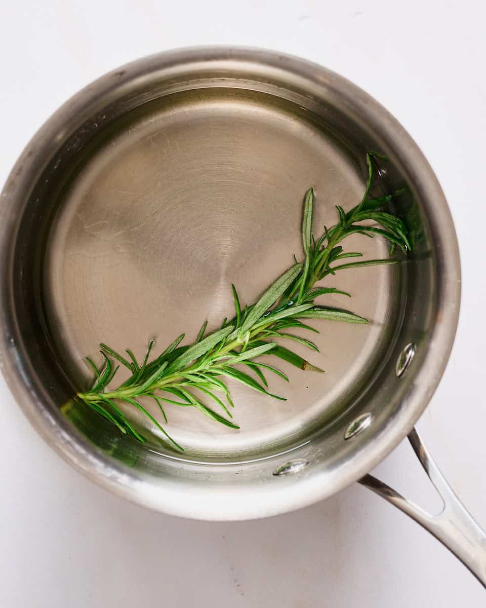 steeping rosemary in a saucepan with homemade sugar free simple syrup