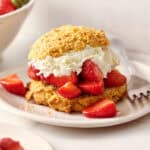 closeup of strawberry shortcakes with fresh whipped cream and shiny berries