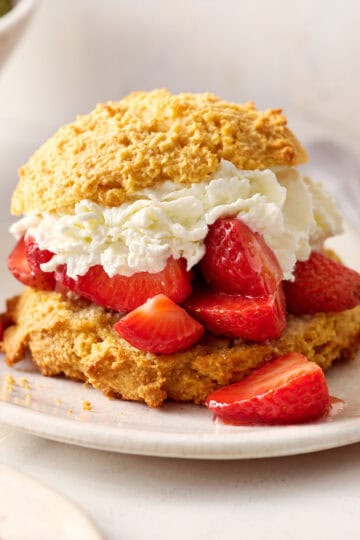 closeup of strawberry shortcakes with fresh whipped cream and shiny berries